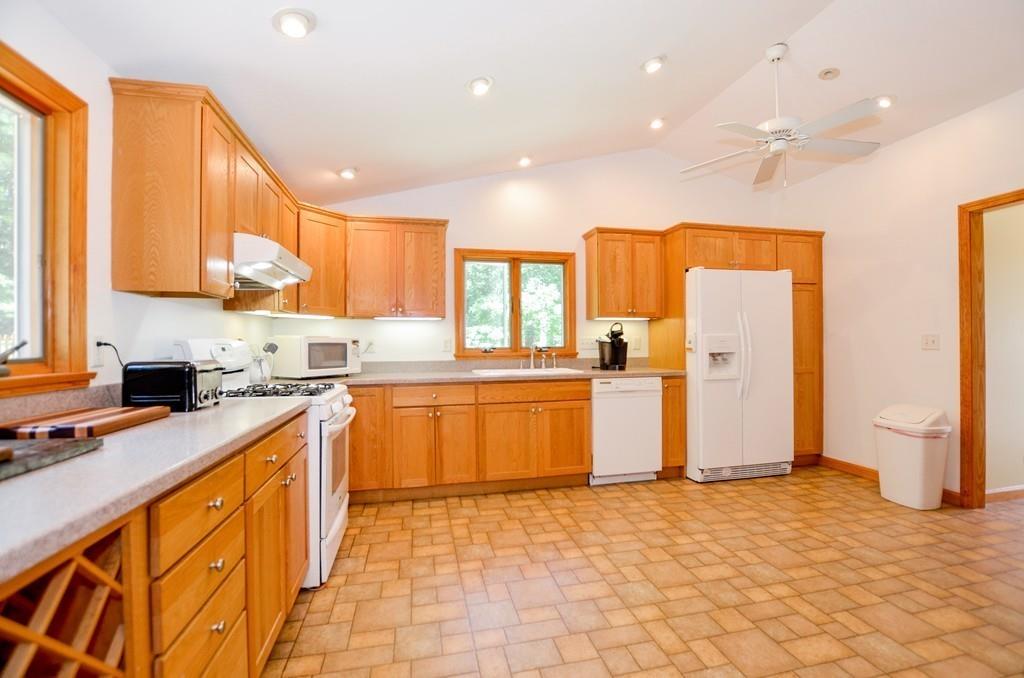 899 Walnut Plain Road Rochester, MA 02770 - Photo 16 of 42 a kitchen with stainless steel appliances granite countertop a refrigerator a sink dishwasher and wooden cabinets with large window