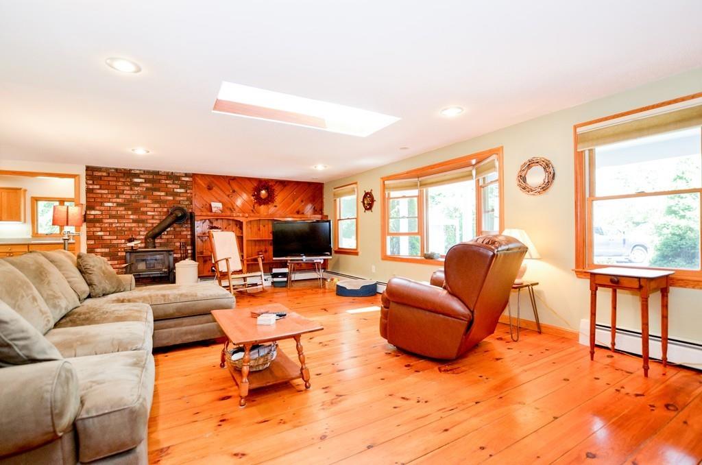 899 Walnut Plain Road Rochester, MA 02770 - Photo 19 of 42 a living room with furniture a large window and a fireplace