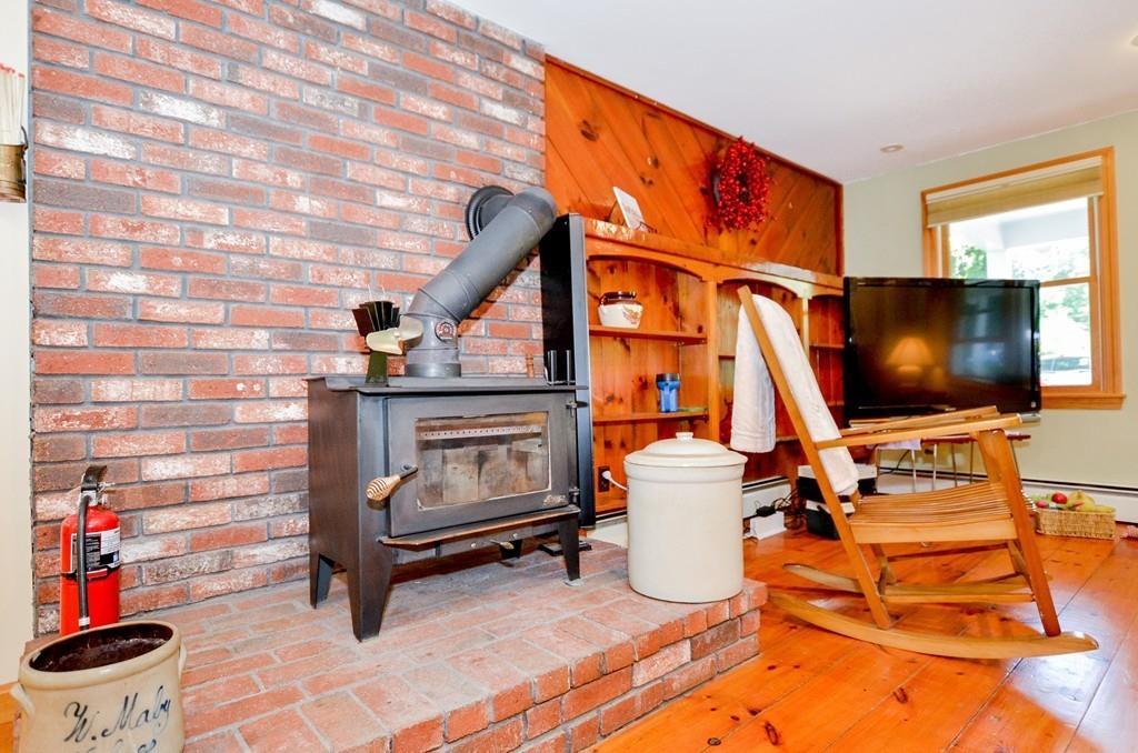 899 Walnut Plain Road Rochester, MA 02770 - Photo 22 of 42 a living room with a flat screen tv and a fireplace