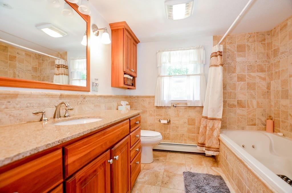 899 Walnut Plain Road Rochester, MA 02770 - Photo 26 of 42 a bathroom with a granite countertop sink mirror bathtub and toilet