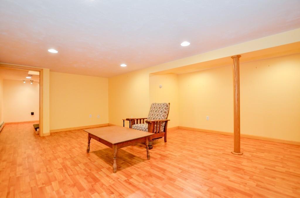 899 Walnut Plain Road Rochester, MA 02770 - Photo 34 of 42 a living room with a table and a rug