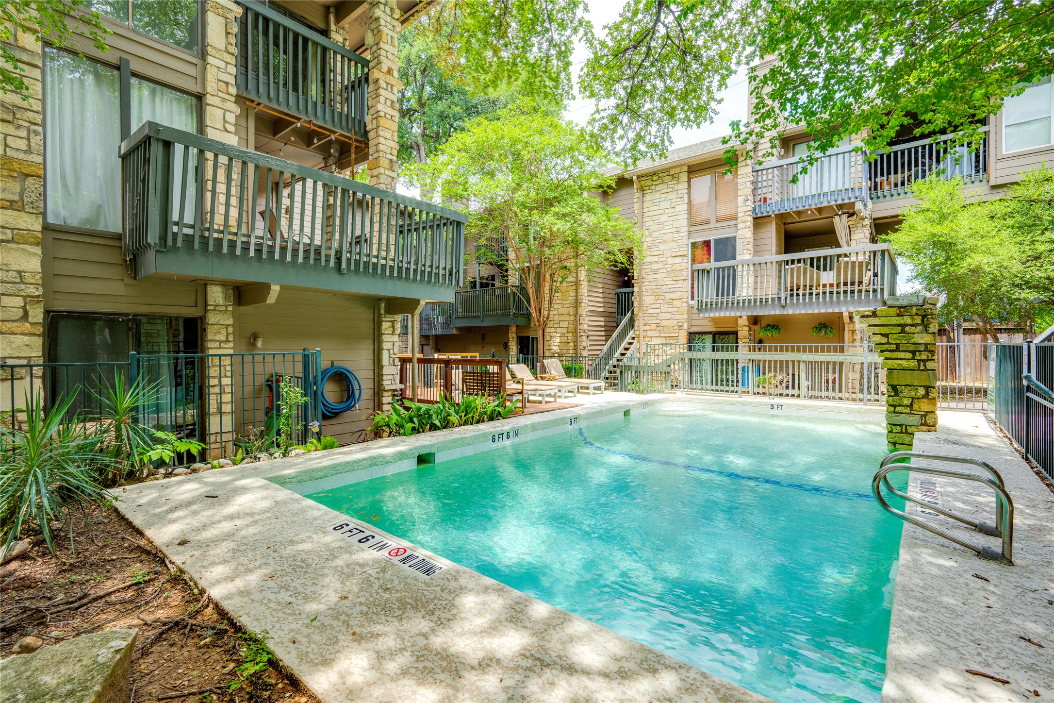 3627 Menchaca Road, Unit 214 Austin, TX 78704 - Photo 26 of 28 Relax poolside in this tranquil setting, surrounded by the natural beauty of the community.