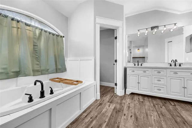 a bathroom with a tub sink and mirror