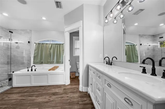a bathroom with a double vanity sink a mirror and a bathtub