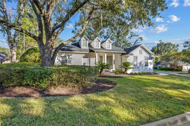 a front view of a house with a garden and trees