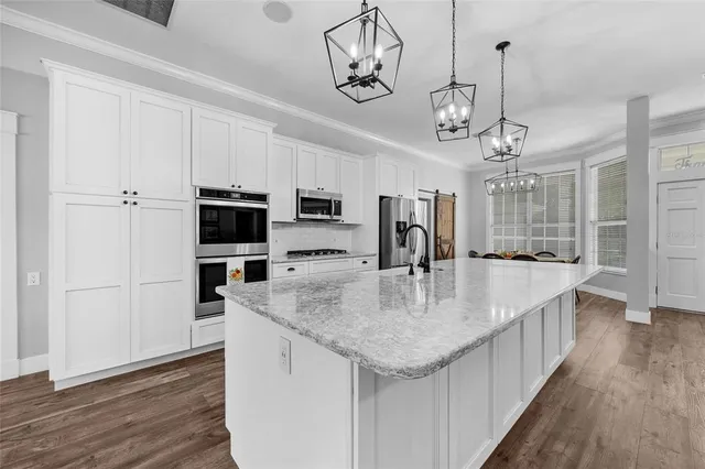 a kitchen with stainless steel appliances granite countertop a sink refrigerator and cabinets