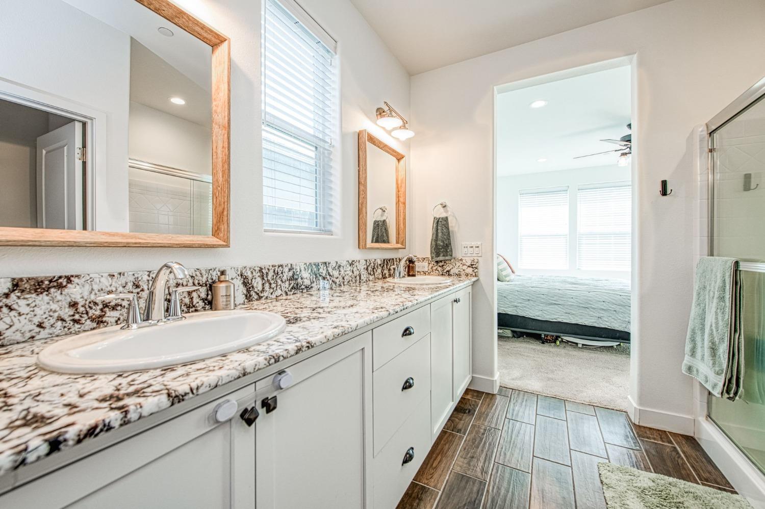408 Grant Avenue West Madera, CA 93636 - Photo 26 of 42 a bathroom with a granite countertop sink and a large mirror