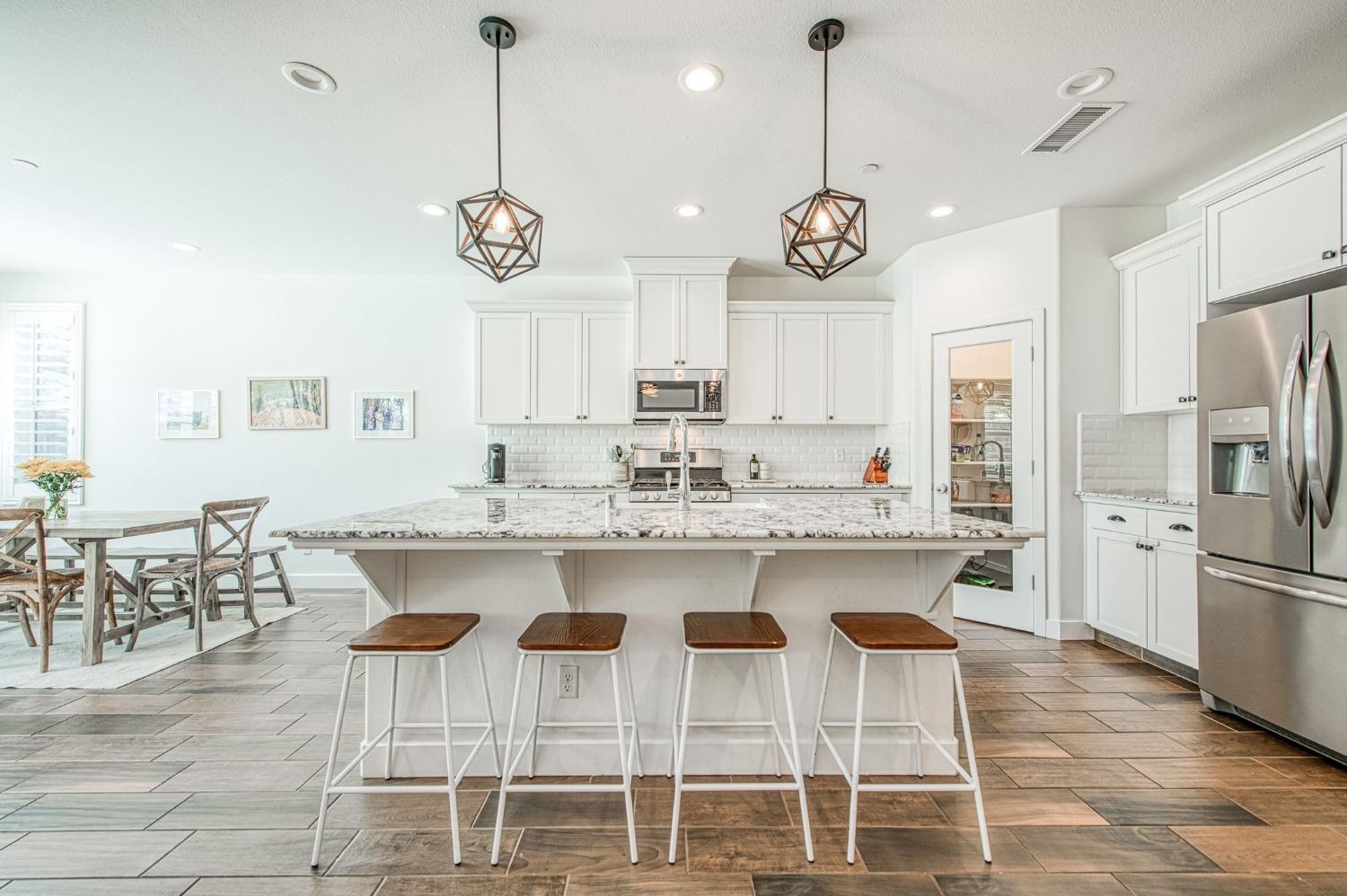 408 Grant Avenue West Madera, CA 93636 - Photo 9 of 42 a kitchen with granite countertop a dining table chairs cabinets and stainless steel appliances