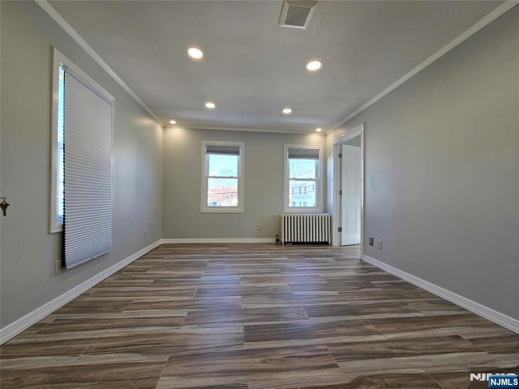 282 Harding Avenue, Unit 2 Teaneck, NJ 07666 - Photo 11 of 17 a view of an empty room with wooden floor and a window