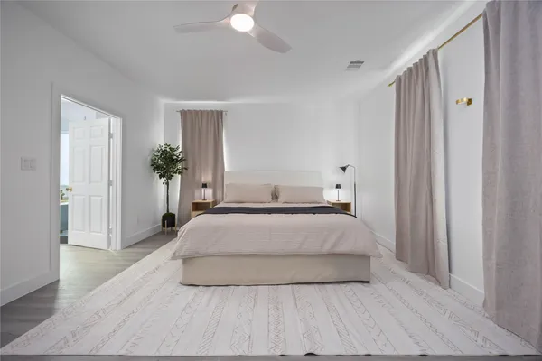 a spacious bedroom with a bed and a window
