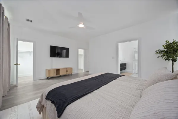 a bedroom with a large bed and a flat screen tv