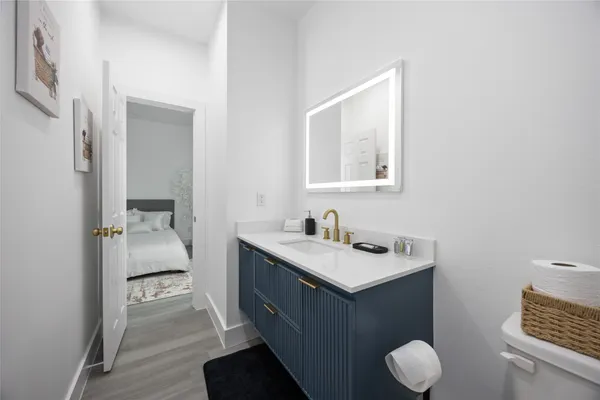 a en suite bathroom with a granite countertop sink and a mirror