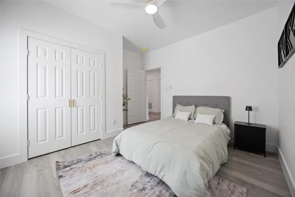 a large bed in a bedroom next to a window and a chandelier