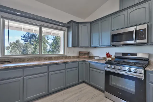 a kitchen with stainless steel appliances granite countertop a stove microwave and cabinets