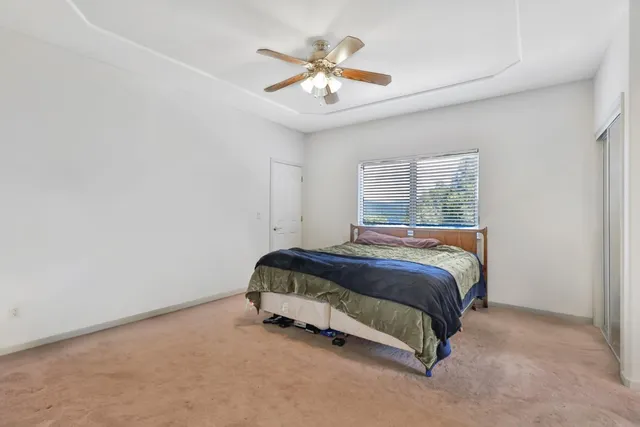 a spacious bedroom with a bed and a ceiling fan
