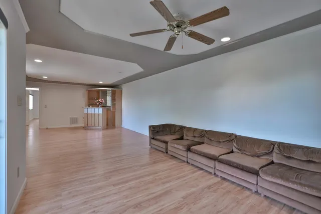 a living room with furniture and a ceiling fan