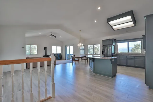 a dining room with wooden floor and large windows
