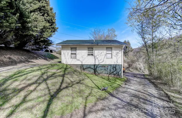 a view of a house with backyard and wooden fence