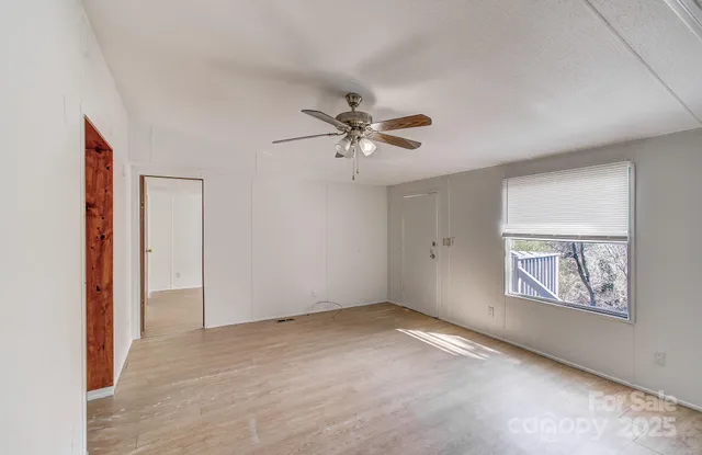 a view of a kitchen with white cabinets and wooden floor