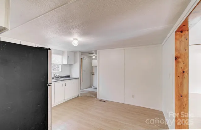 a kitchen with a sink a refrigerator and cabinets