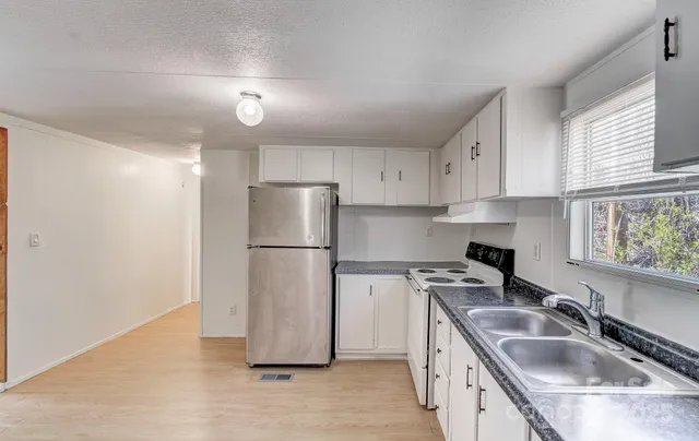 a kitchen with a refrigerator a sink and cabinets