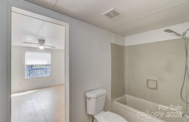 a white toilet sitting next to a bath tub