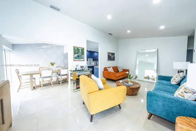 a living room with furniture and a view of kitchen