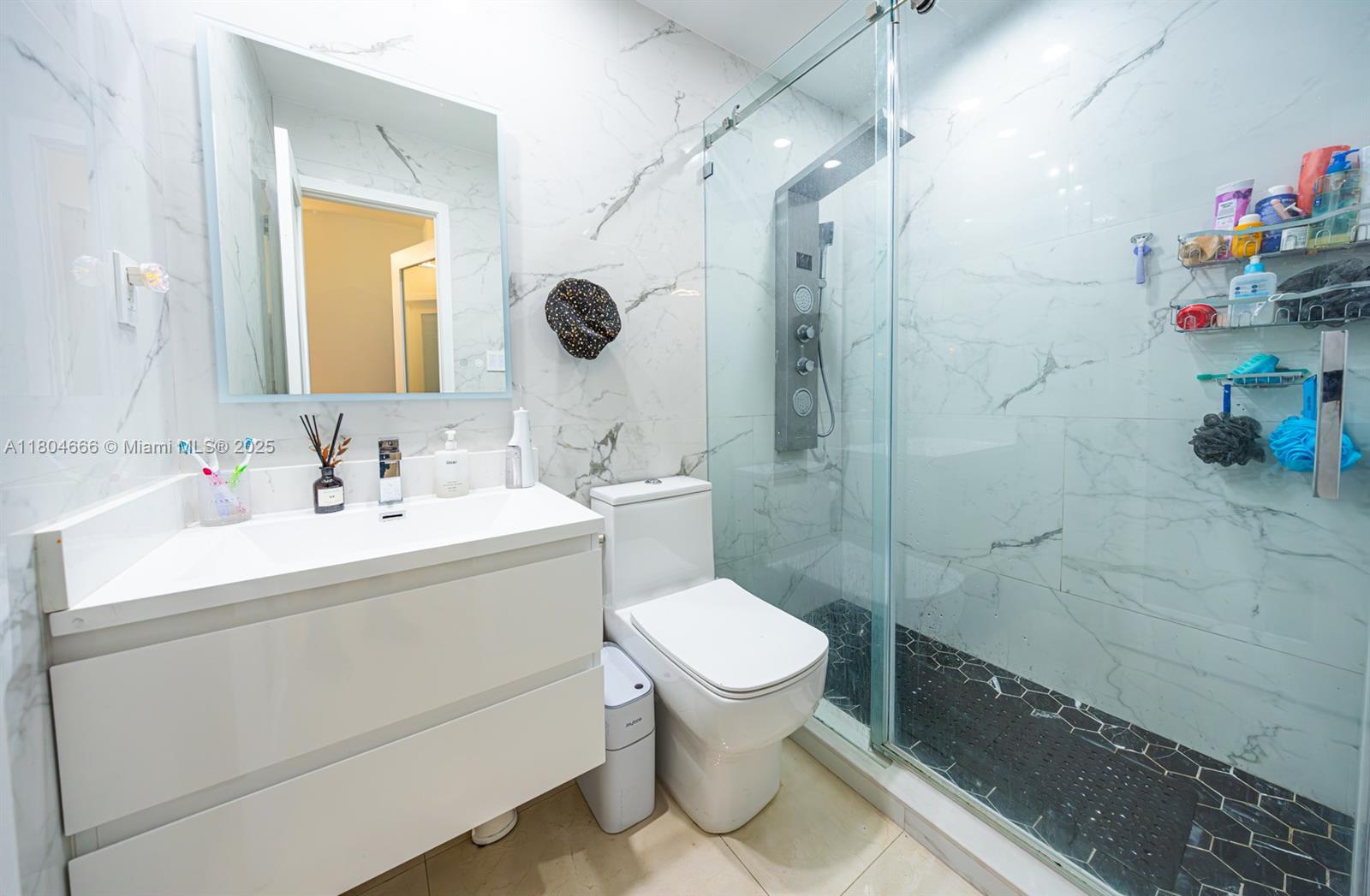 6950 Northwest 168th Street Hialeah, FL 33015 - Photo 15 of 28 a bathroom with a sink toilet vanity and shower