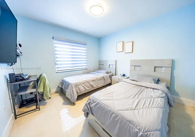 a bedroom with two beds and a window