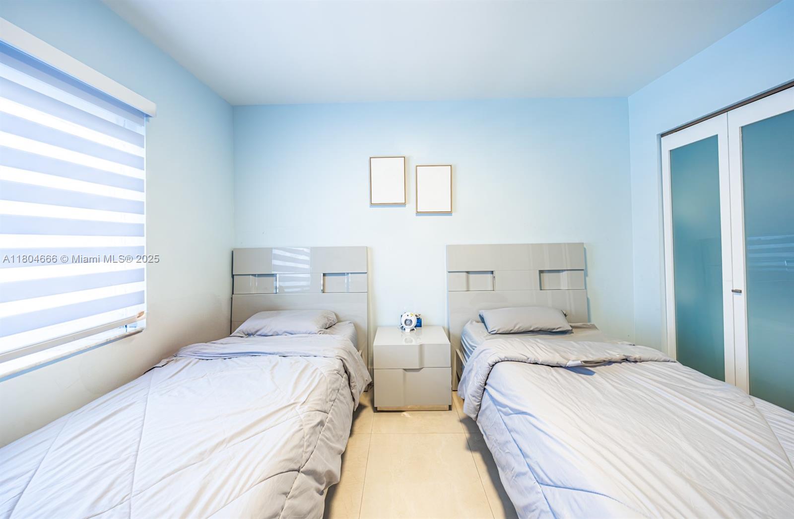 6950 Northwest 168th Street Hialeah, FL 33015 - Photo 20 of 28 a bedroom with two beds and a window