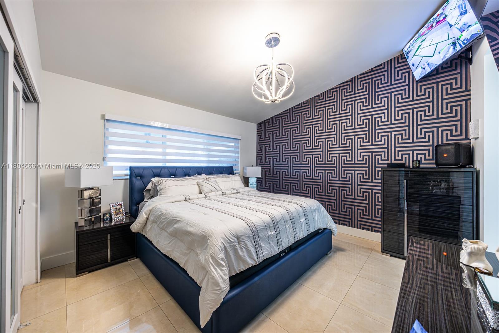 6950 Northwest 168th Street Hialeah, FL 33015 - Photo 23 of 28 a bedroom with a bed and a chandelier