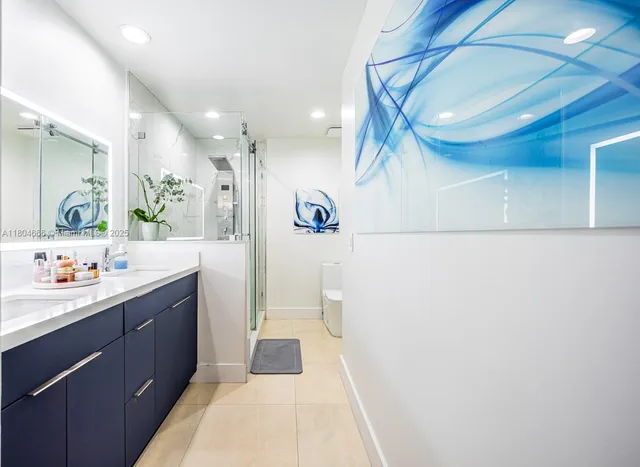 a en suite bathroom with double vanity a mirror and a shower