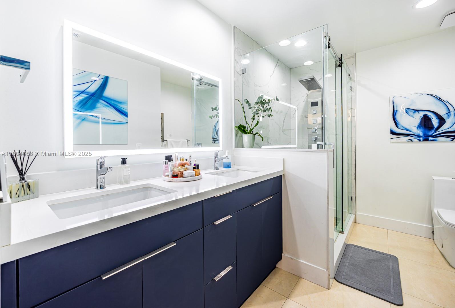 6950 Northwest 168th Street Hialeah, FL 33015 - Photo 26 of 28 a en suite bathroom with double vanity a mirror and a shower