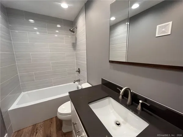 a bathroom with a sink a toilet and shower