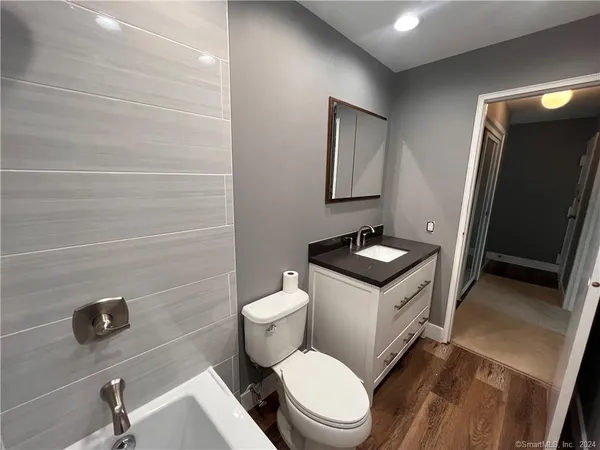a bathroom with a toilet sink and mirror