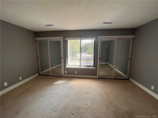 a view of a big room with windows and chandelier