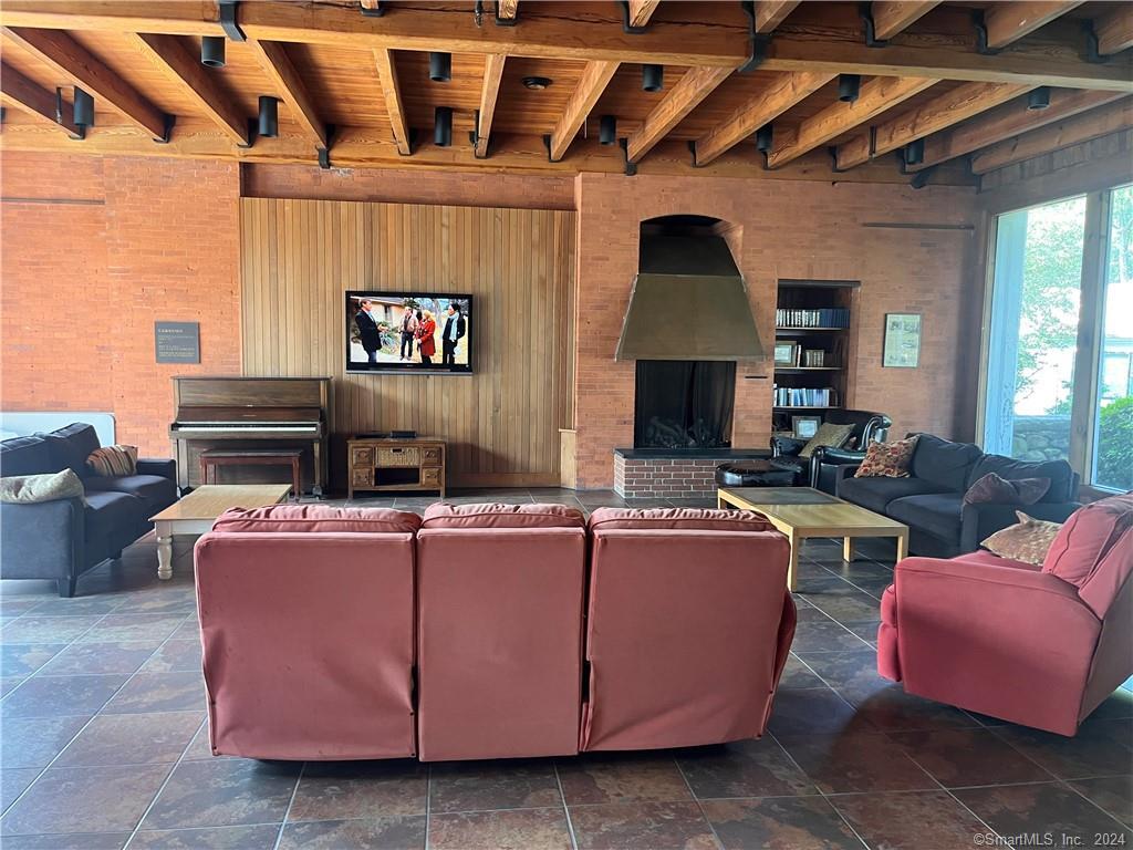 60 Olcott Way, Unit 60 Ridgefield, CT 06877 - Photo 26 of 31 a living room with furniture a fireplace and a table