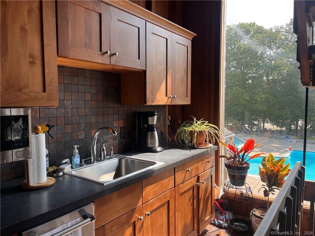60 Olcott Way, Unit 60 Ridgefield, CT 06877 - Photo 27 of 31 a kitchen with stainless steel appliances granite countertop a sink a stove and a microwave