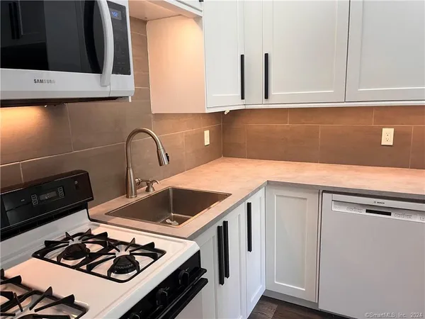 a kitchen with a sink stove and cabinets