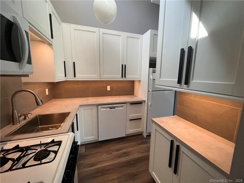 60 Olcott Way, Unit 60 Ridgefield, CT 06877 - Photo 9 of 31 a kitchen with stainless steel appliances a stove microwave and sink
