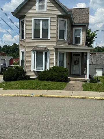 a front view of a house with a garden and plants