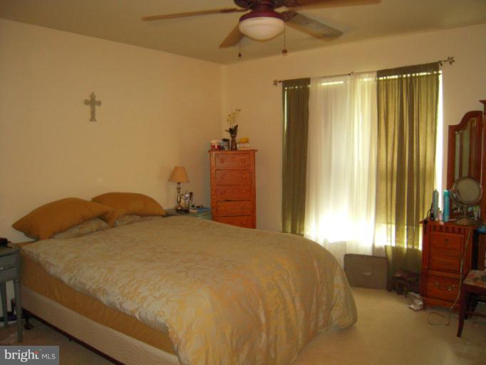 5478 Stavendish Street Burke, VA 22015 - Photo 20 of 30 a bedroom with a bed and a chandelier