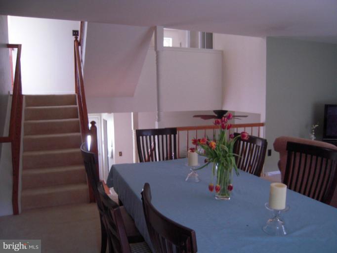 5478 Stavendish Street Burke, VA 22015 - Photo 22 of 30 a view of a dining room with furniture a potted plant and wooden floor