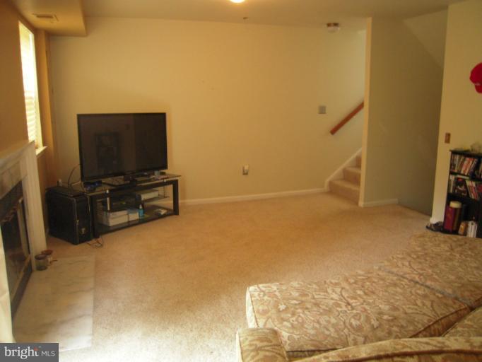 5478 Stavendish Street Burke, VA 22015 - Photo 7 of 30 a view of room with wooden floor and a flat screen tv