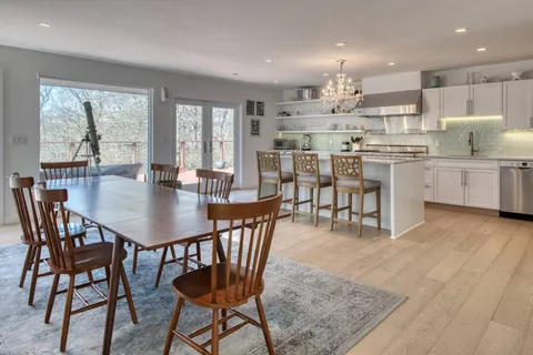 a kitchen with kitchen island a dining table and chairs