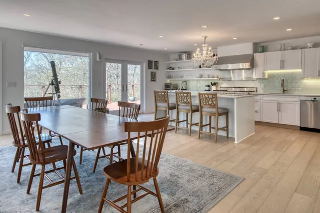 a kitchen with kitchen island a dining table and chairs