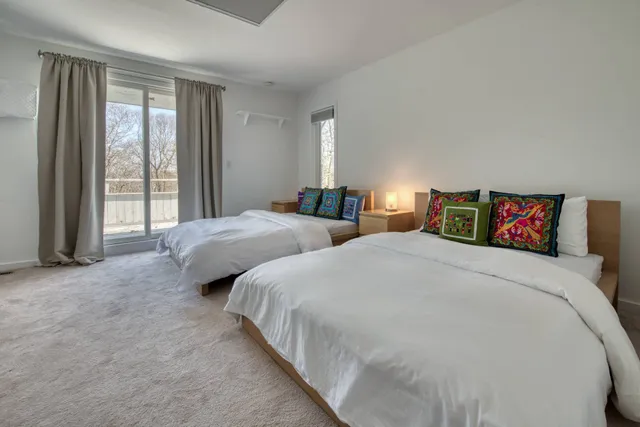 a spacious bedroom with two beds and a large window