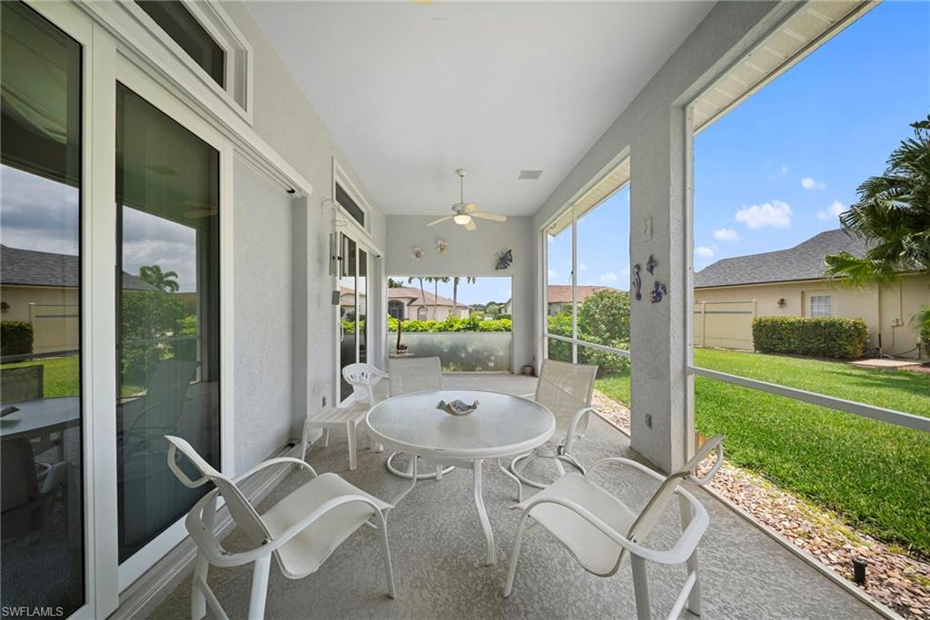 3971 Spring Garden Lane Estero, FL 33928 - Photo 8 of 31 a view of a patio with table and chairs potted plants with wooden floor and fence