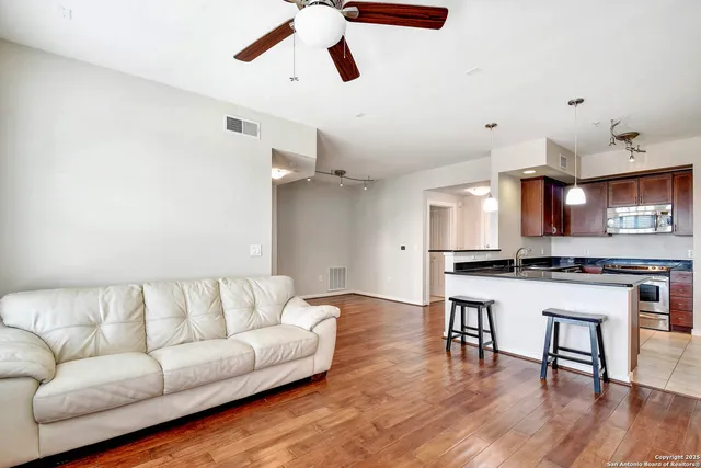 a living room with stainless steel appliances kitchen island a table and chairs