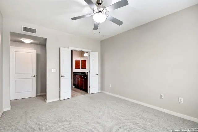 an empty room with closet and a ceiling fan
